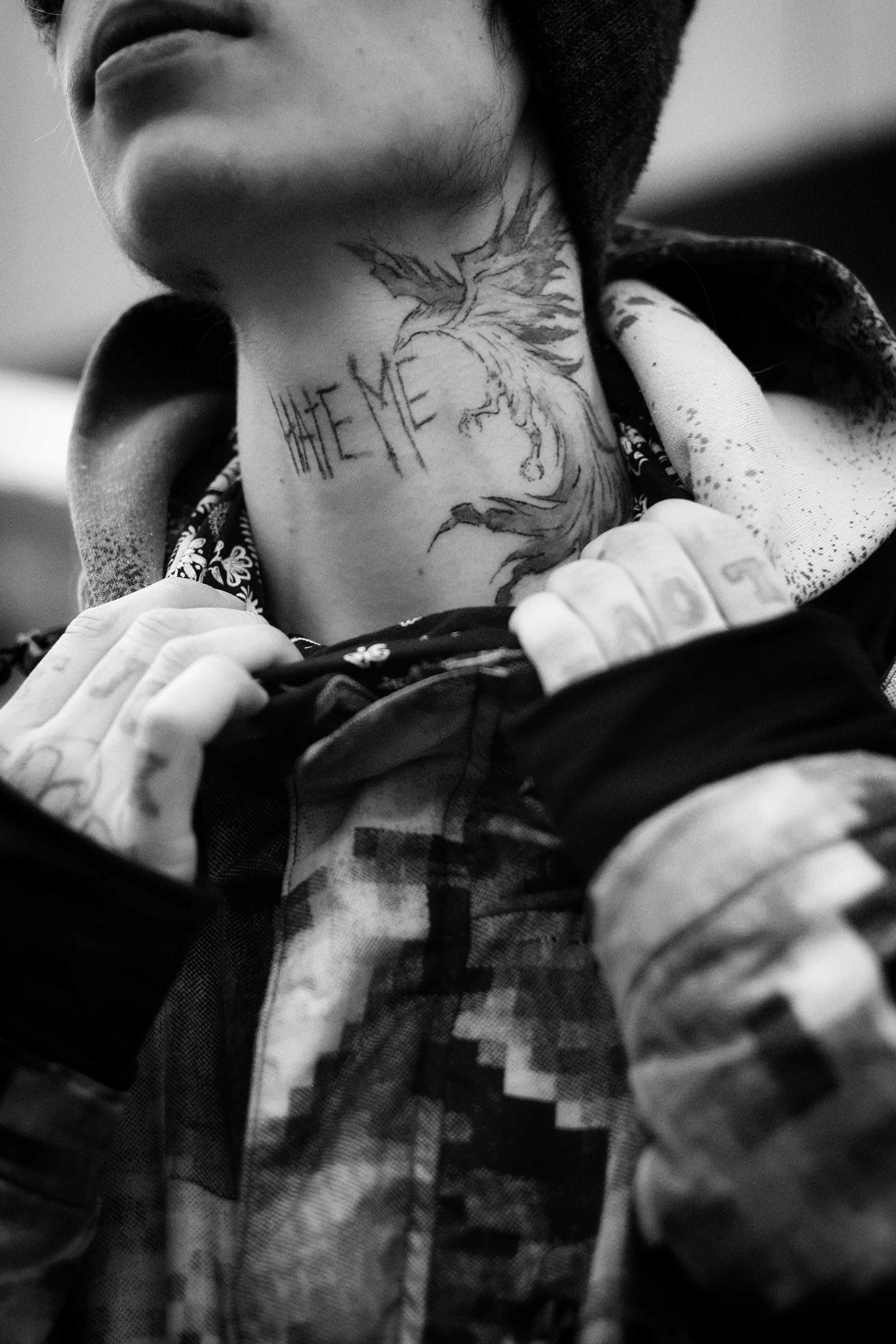 Tatuagem de fênix em blackwork no pescoço com lettering abaixo